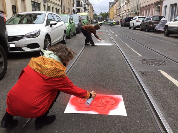 Auf die Bürgerstraße in Dresden werden Symbole für mehr Verkehrssicherheit für Radfahrende geprüht
