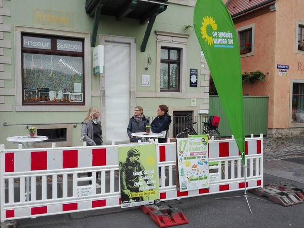 Diskussion am Laubegaster Ufer in Dresden zur Europäischen Mobilitätswoche 2021 (drei Frauen sprechen miteinander + grüne Beachflag und Plakate zu sehen)