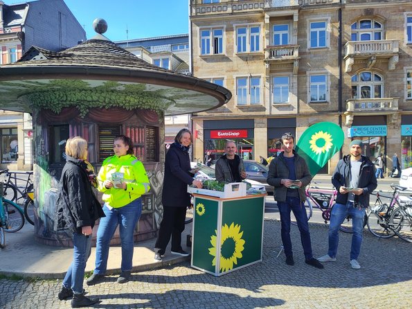 Menschen am Schillerplatz Dresden mit grünem Infostand und Beachflag