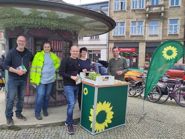 Menschen am Schillerplatz Dresden mit grünem Infostand und Beachflag